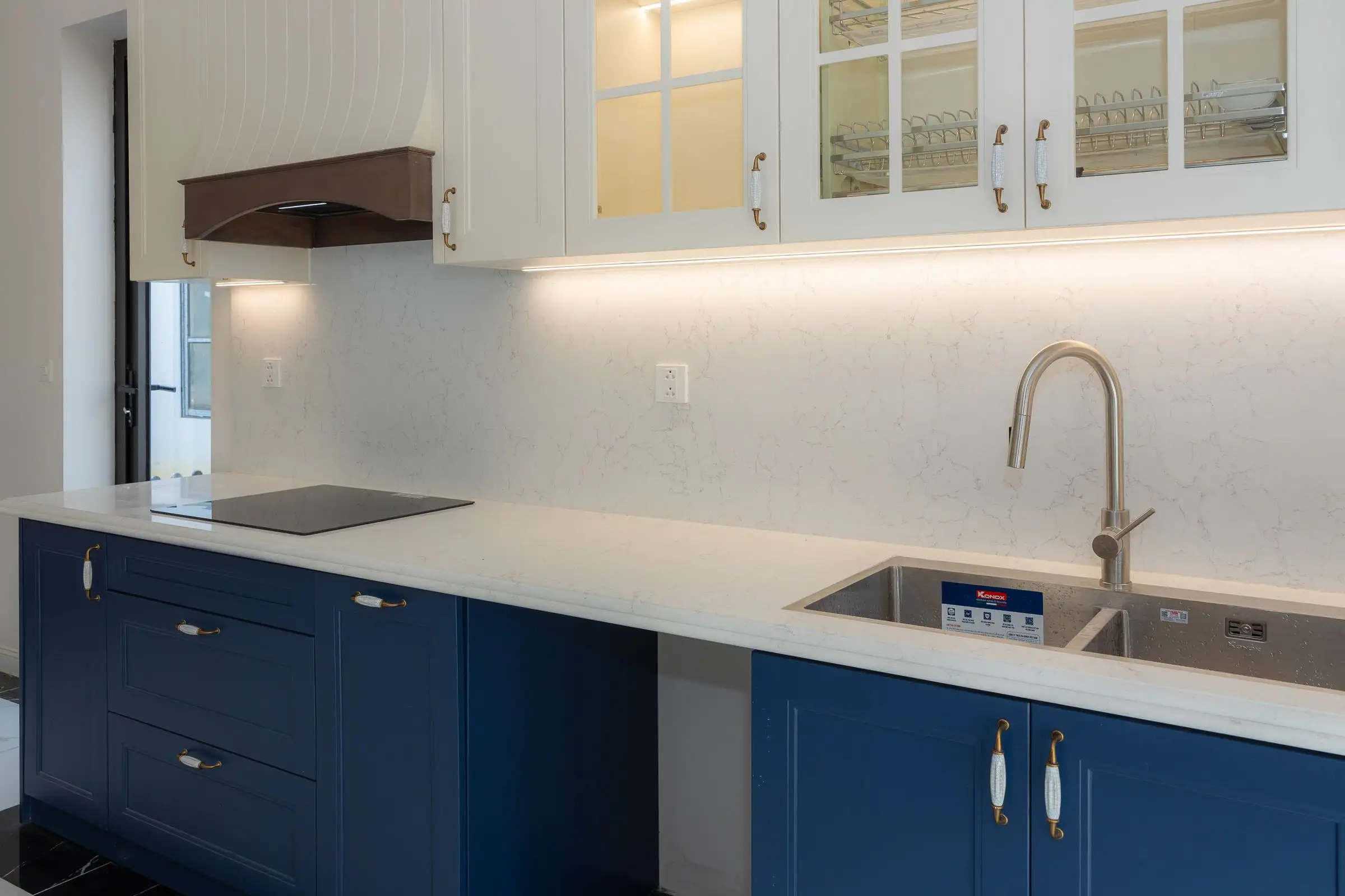 Blue kitchen cabinets under a plain white countertop