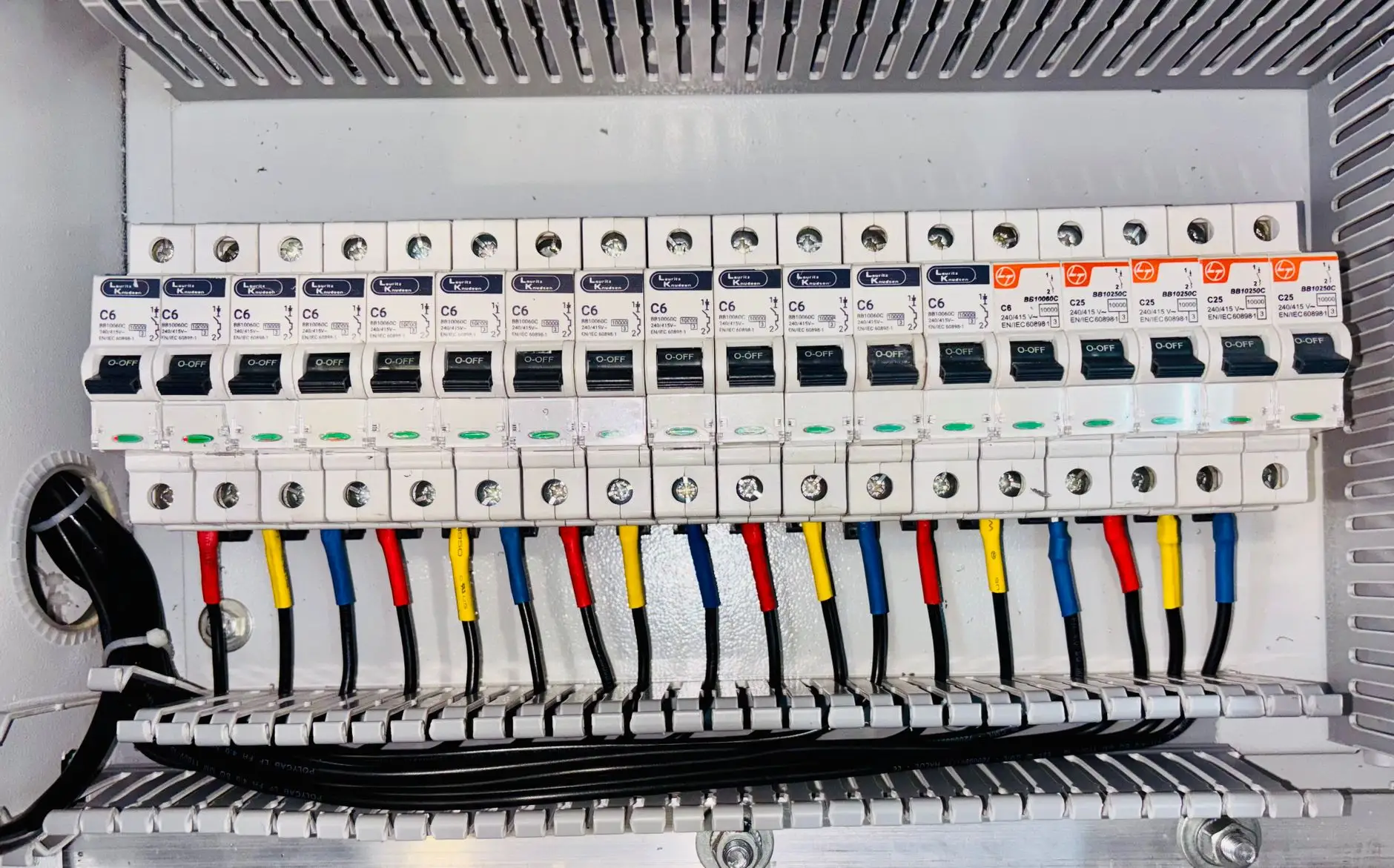Rangée de disjoncteurs alignés dans un tableau électrique