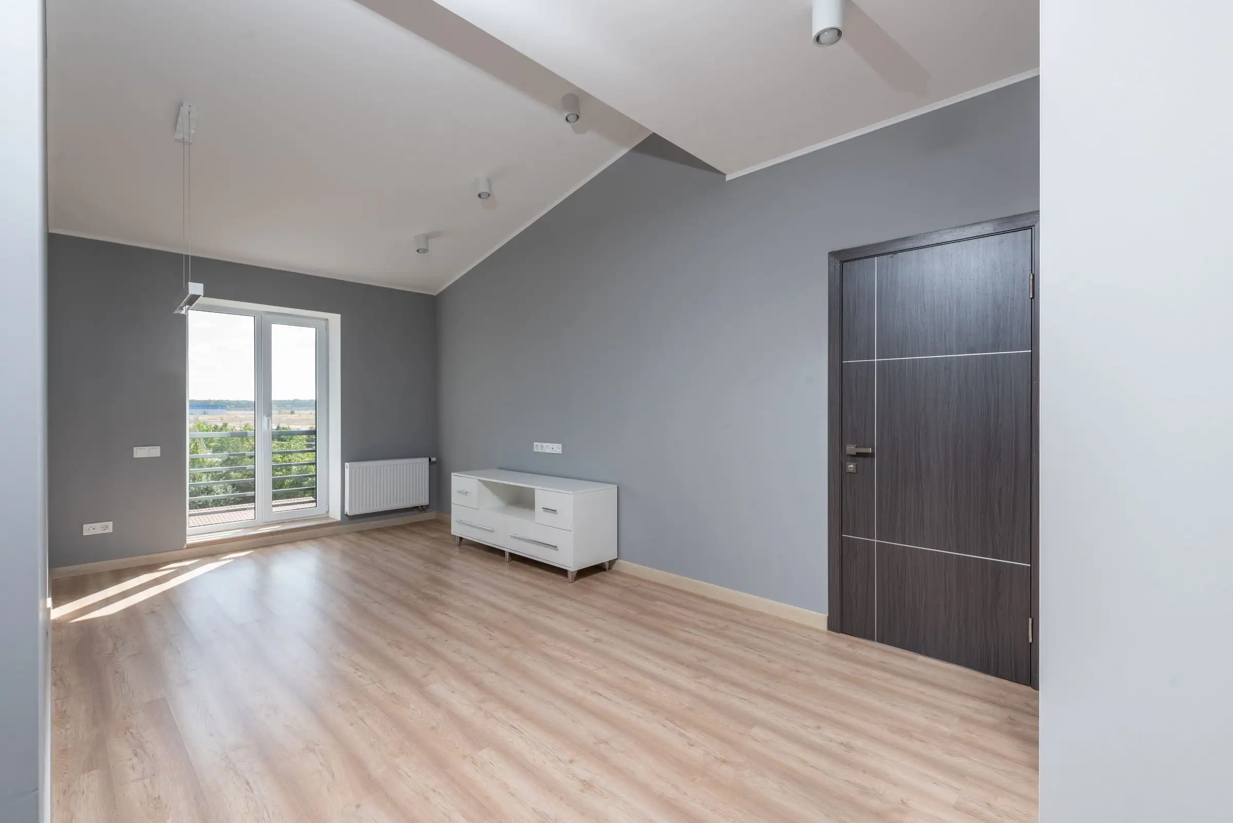 Bright empty room with a wood floor and a window view