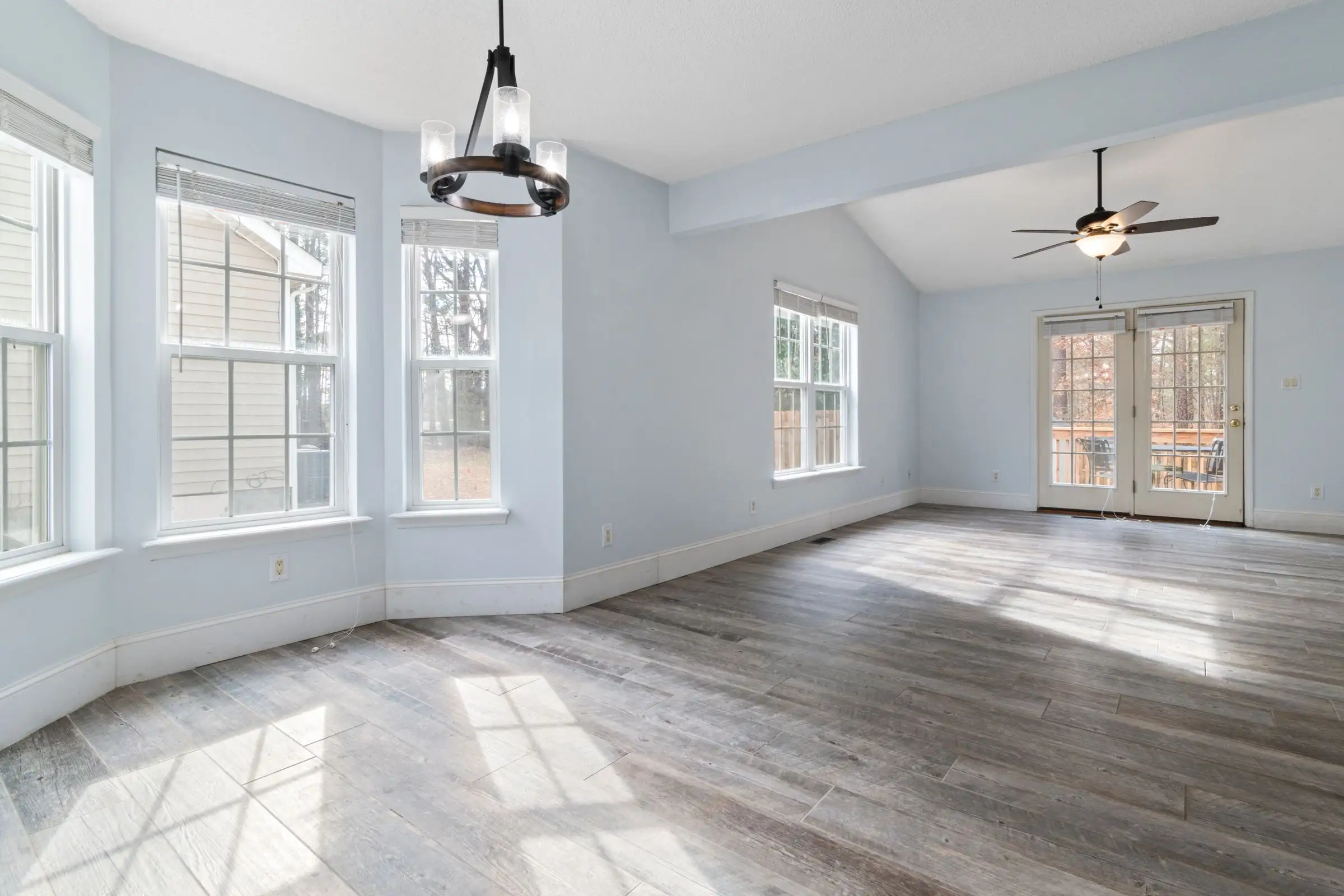 Empty living room with a bare wood floor waiting to be replaced