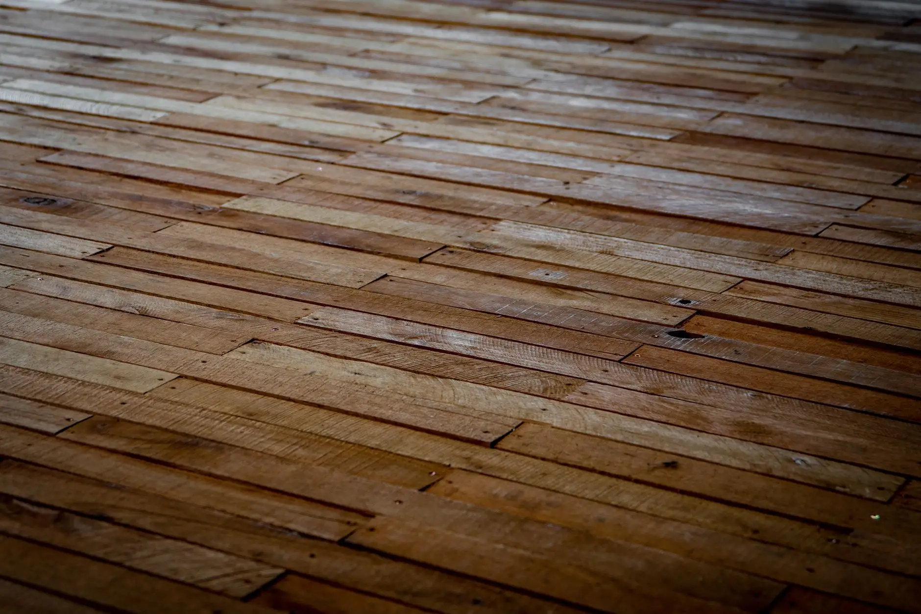 Newly laid wood planks running diagonally to the edge of the frame