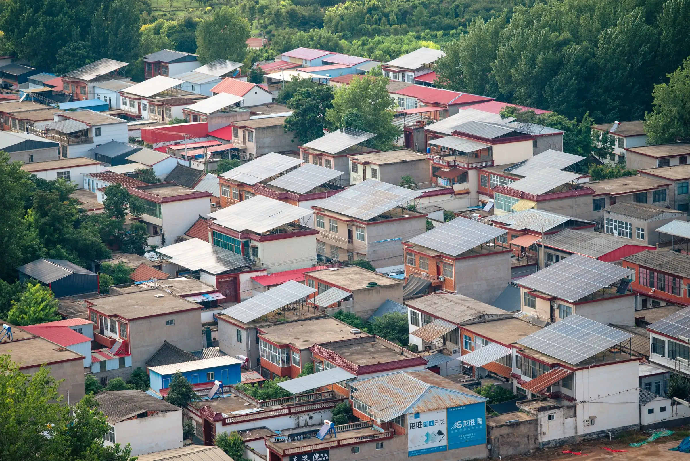 Aerial view of a suburban neighborhood with arrays on several roofs