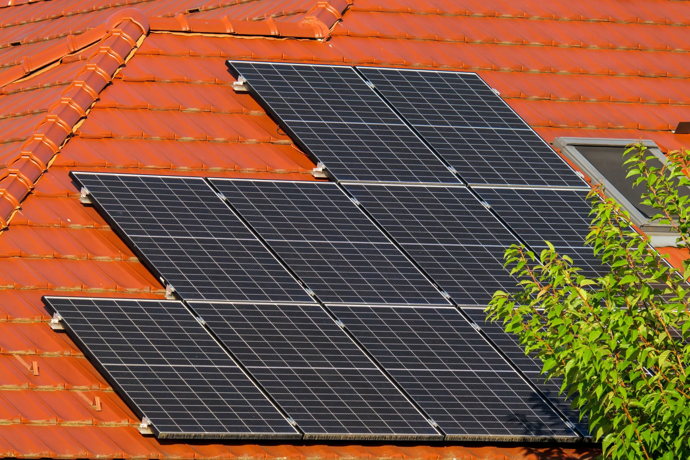 Solar panels bolted above a tiled roof, seen along the rails