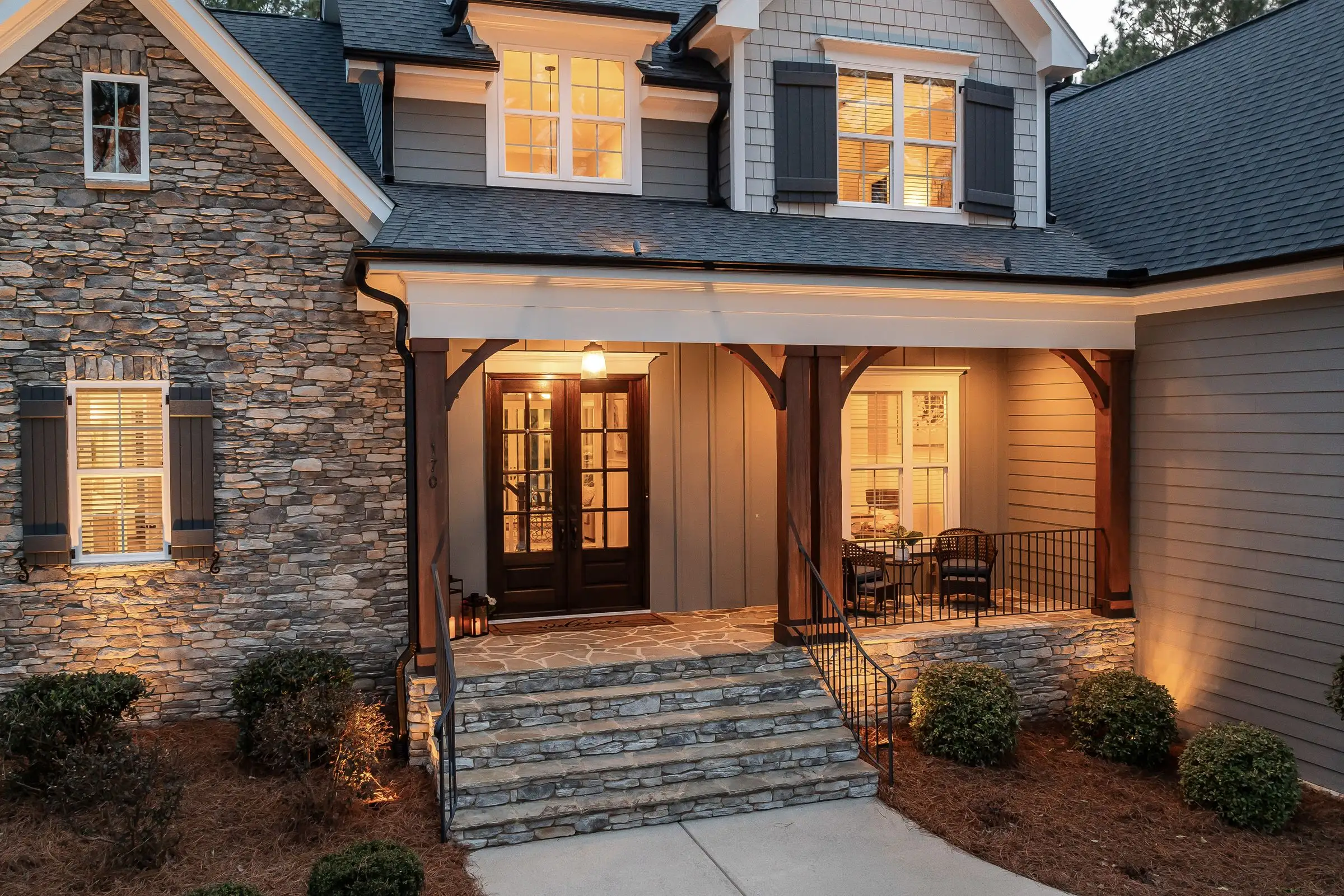 Stone-faced house porch lit warmly at dusk