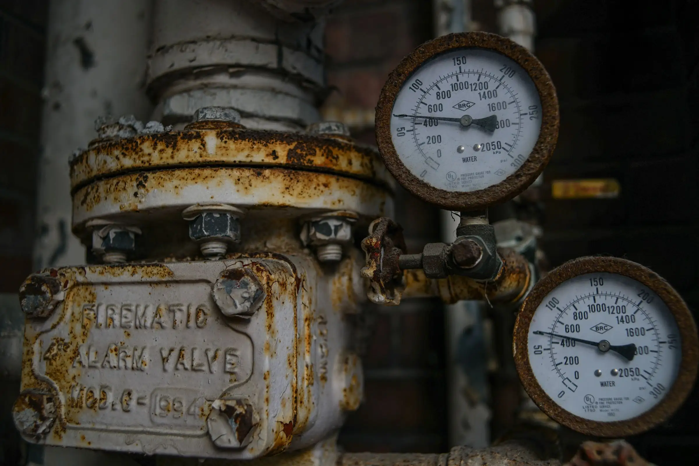 Aged pressure gauge and valve on a heating system, dial dulled with rust