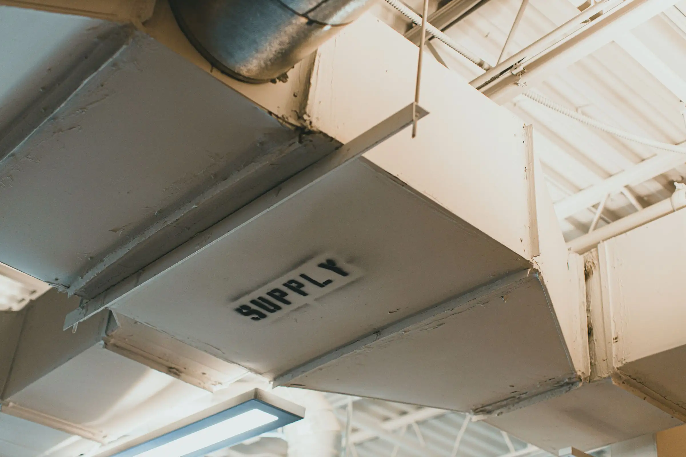 Galvanised duct stencilled with the word SUPPLY