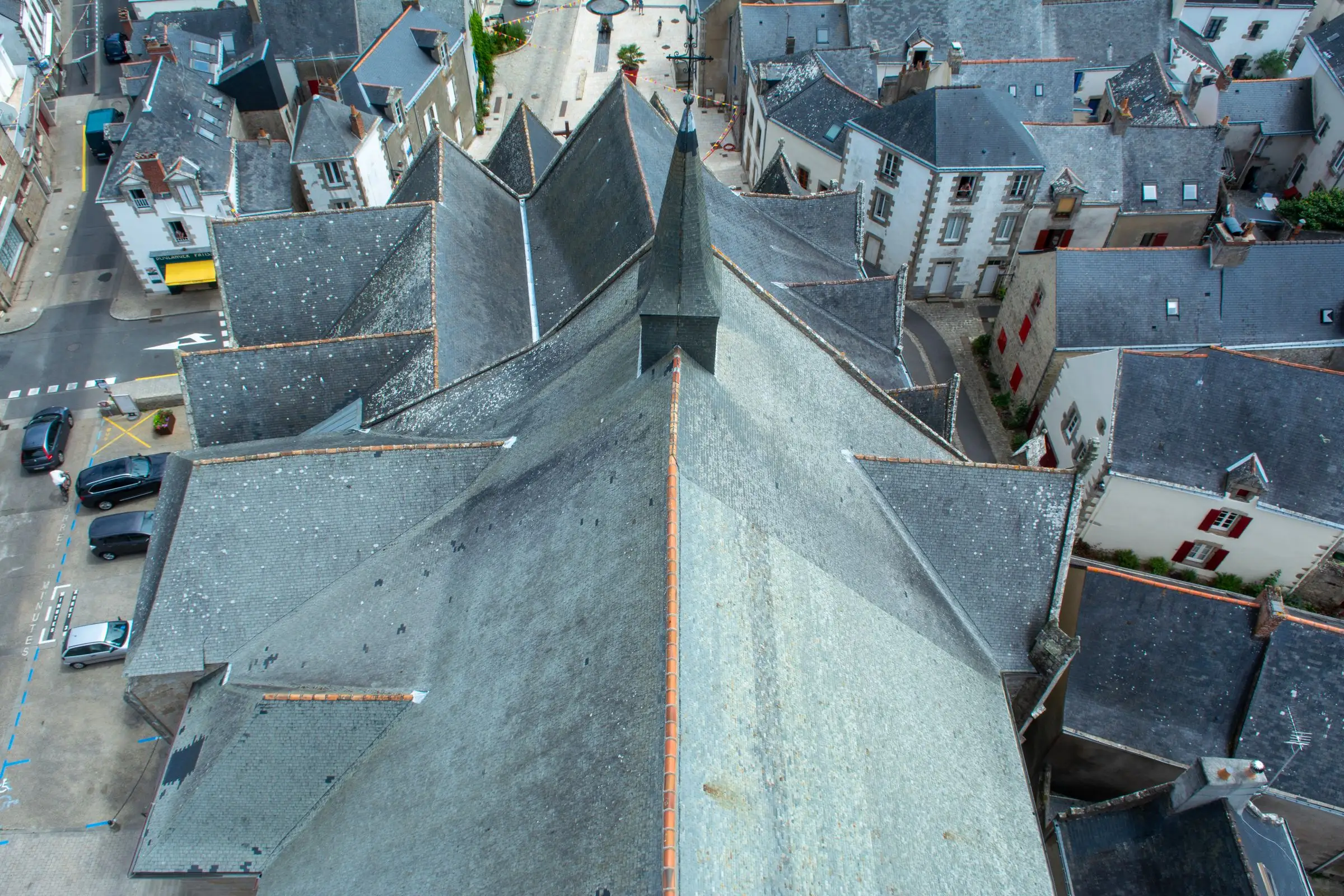 Toits d’une ville côtière bretonne vus d’en haut, ardoises et cheminées serrées le long des rues
