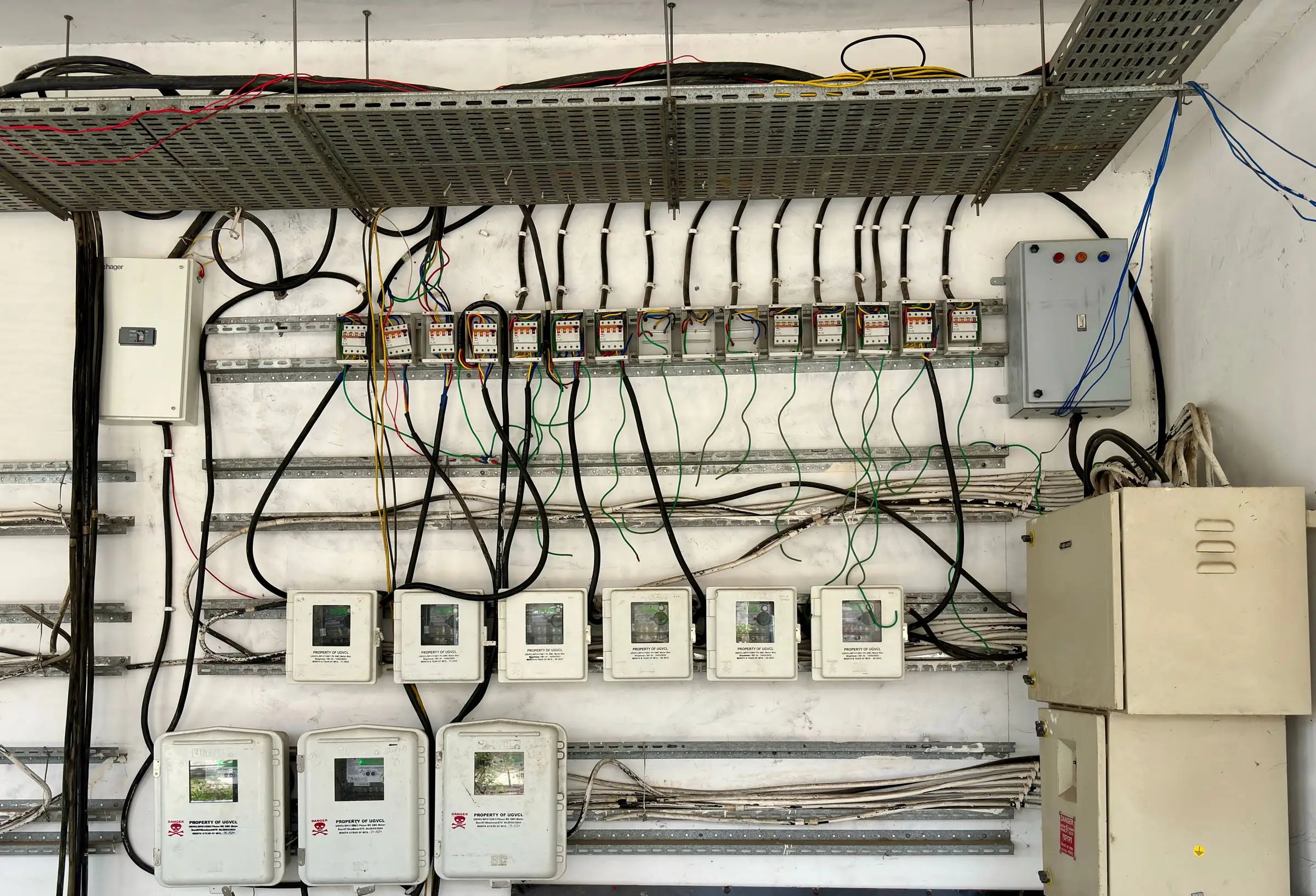 Dense bundle of wiring running into a bank of electrical panels