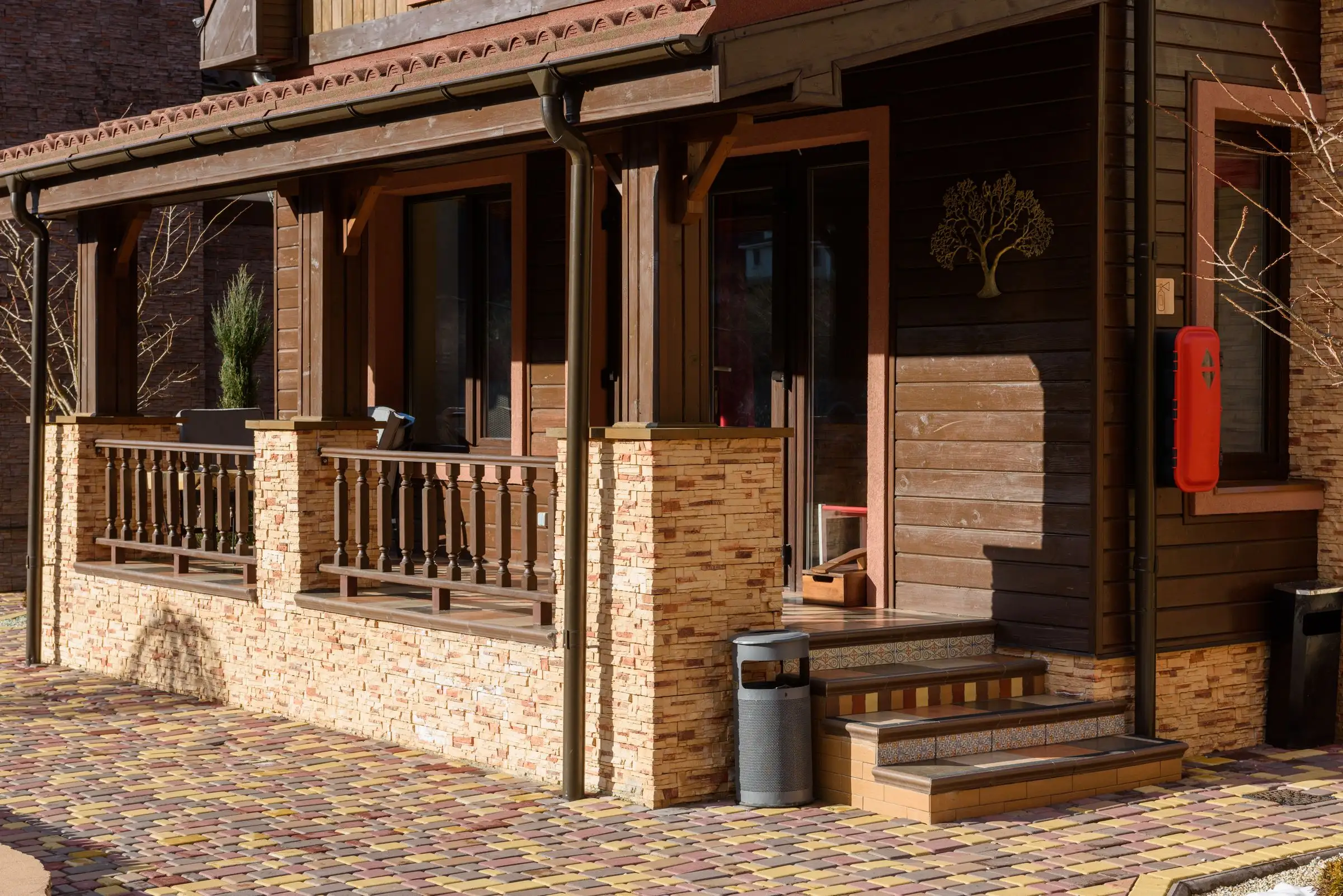 House front combining wood siding and a stone base under a covered porch